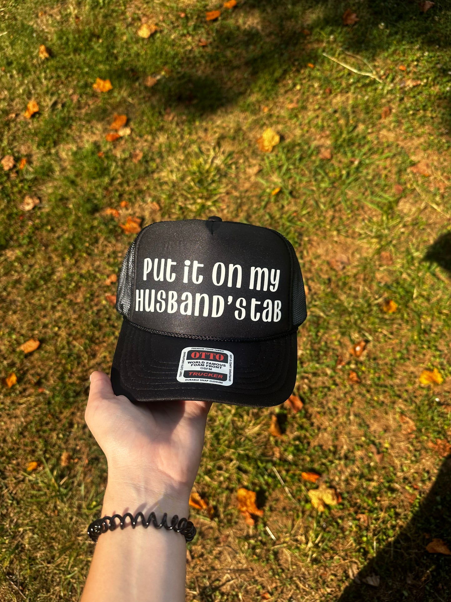 PUT IT ON MY HUSBANDS TAB Trucker Hat